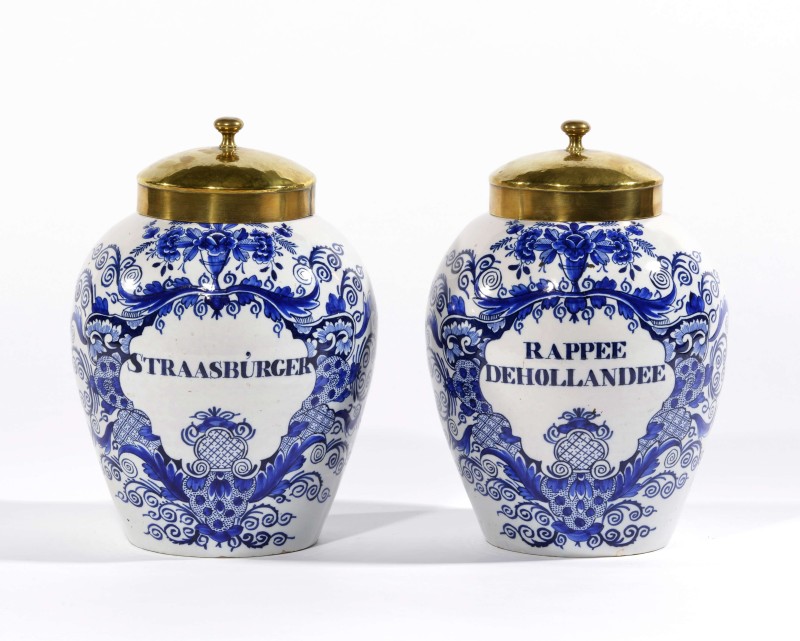 Blue and white Delftware tobacco jars with brass covers on white background